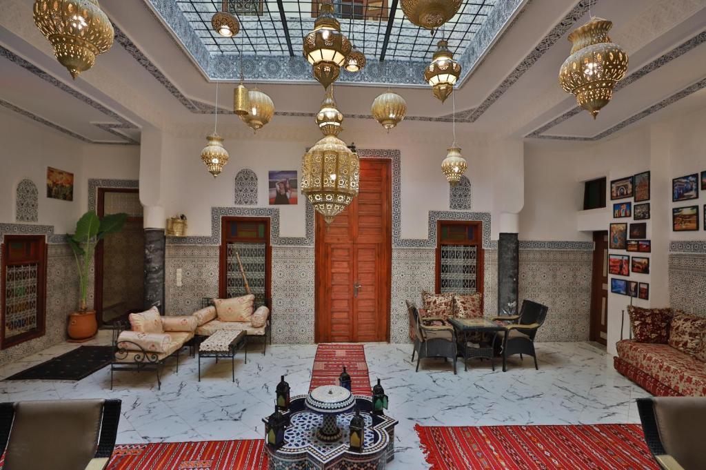 a large living room with furniture and a chandelier at Riad bel kaid fes in Fès