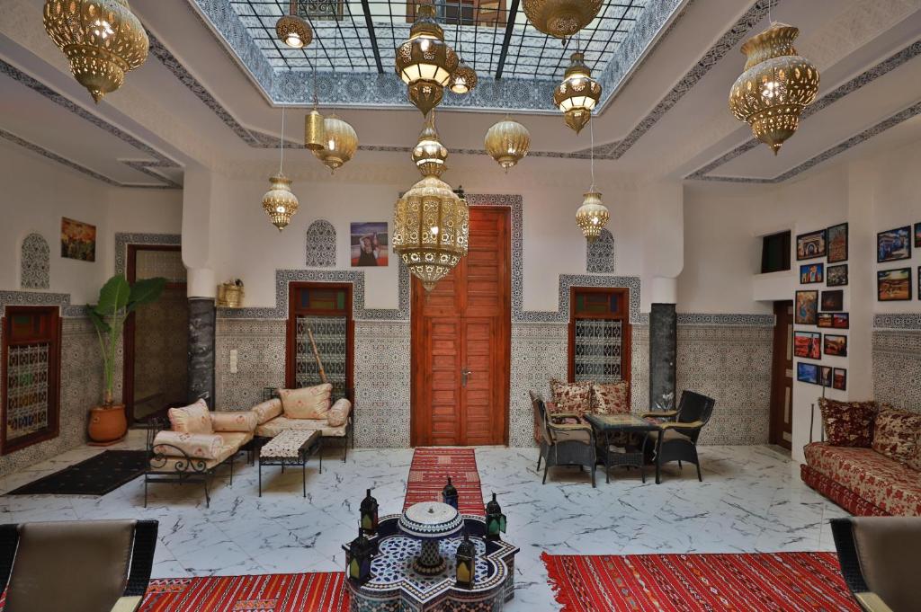 een grote woonkamer met meubilair en een kroonluchter bij Riad bel kaid fes in Fès
