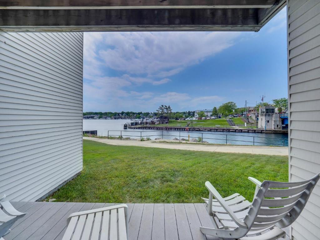 a porch with two chairs and a view of the water at 118A Edgewater Inn in Charlevoix