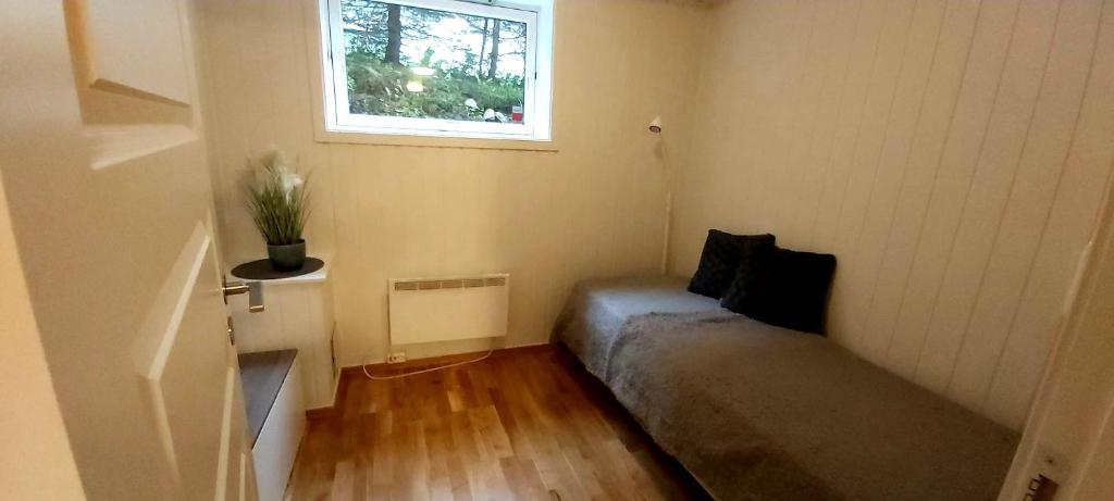 トロムソにあるAurora rooms in shared hsuse nr3 we are doing Northen Lights trip, Reaindear trip and Sommaroy Fjord tripsのベッドと窓のある小さな部屋