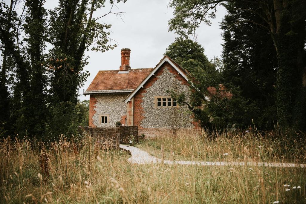 een oud stenen huis in het midden van een veld bij The Coach House in Cholderton