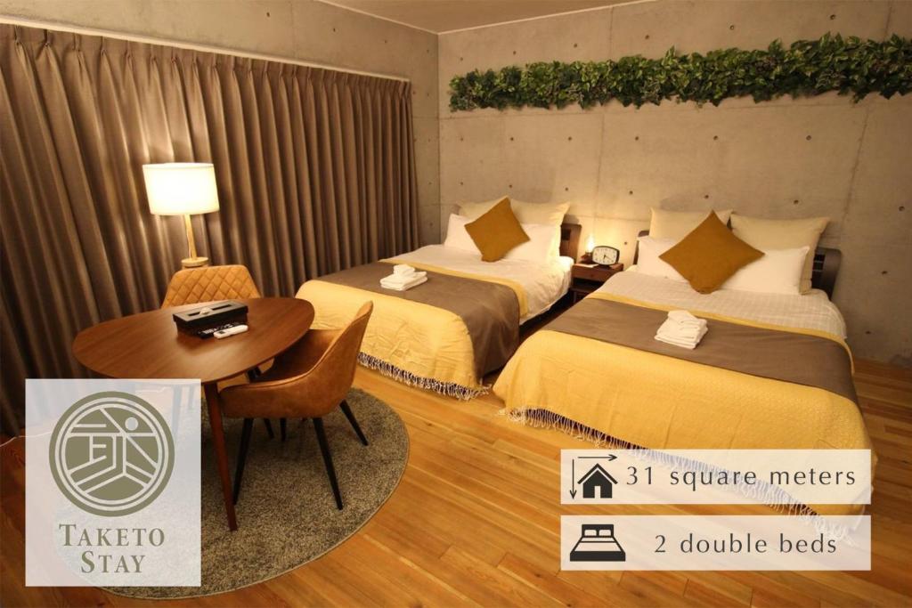 a hotel room with two beds and a table at TAKETO STAY OSAKAJO 9F - Vacation STAY 09349v in Osaka