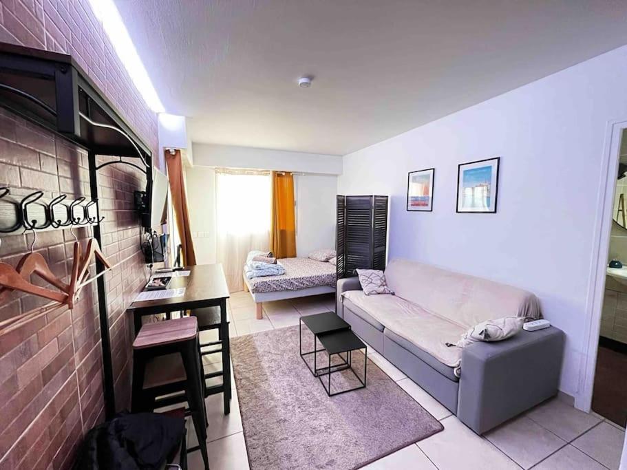 un salon avec un canapé et une table dans l'établissement Parking + piscine, tout confort, proche aéroport & mer, à Saint-Laurent-du-Var