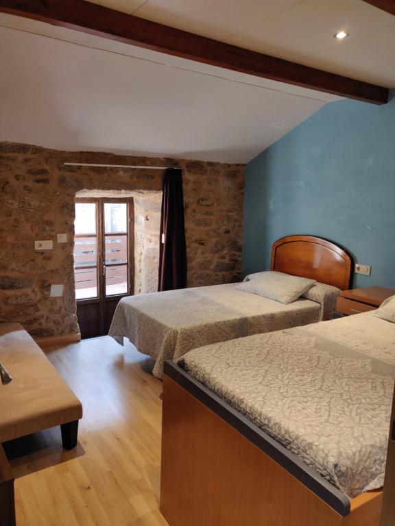 a hotel room with two beds and a window at Casa do Boedo in Camariñas