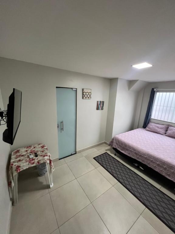 a bedroom with a bed and a chair and a window at Hangar House in Belém