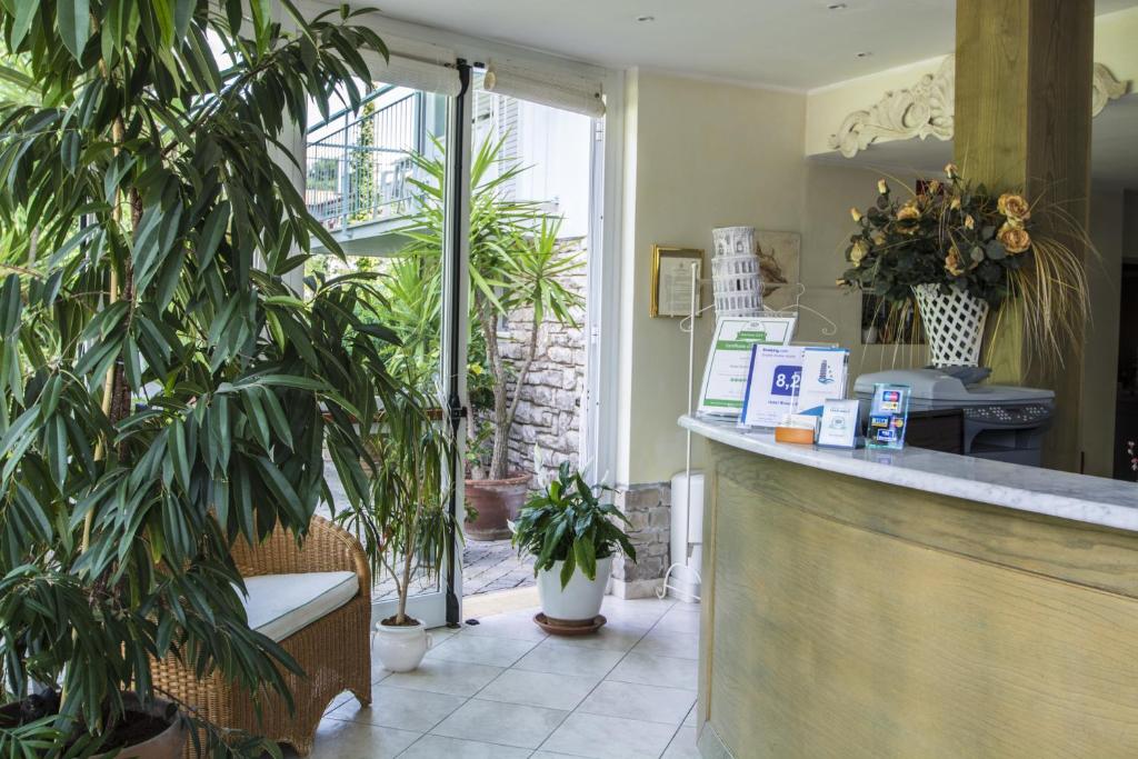a restaurant with potted plants and a counter at Hotel Riviera Blu in Tirrenia