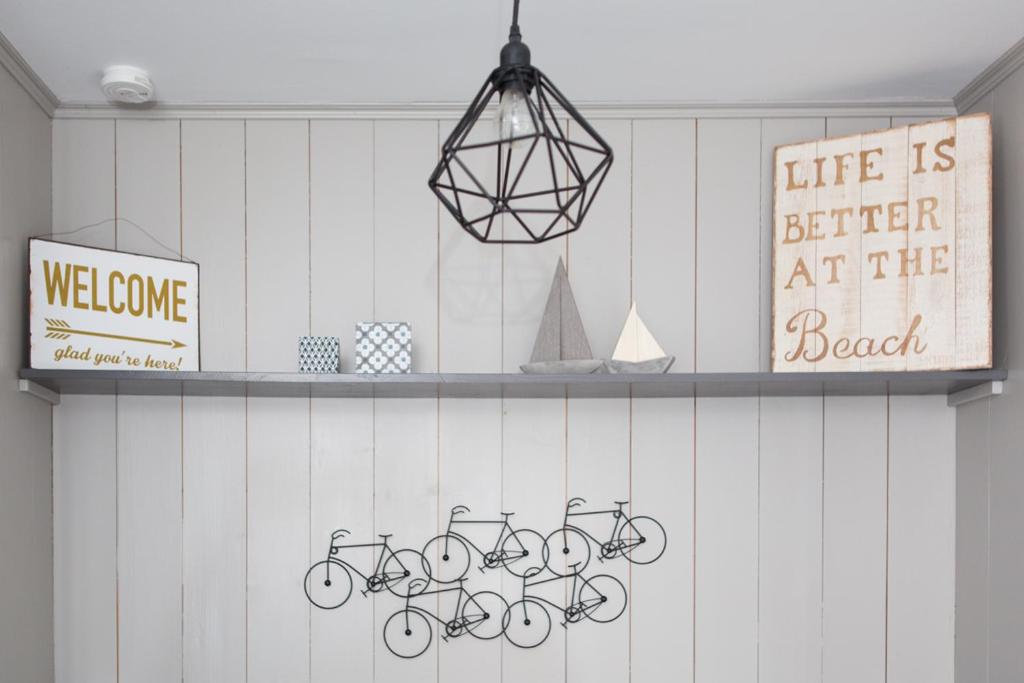 a shelf with bikes on a wall with a sign at Le Clos des Sternes in La Flotte
