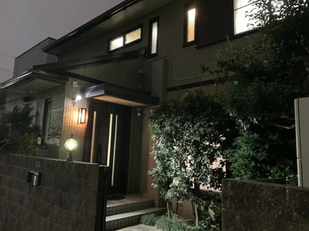 Ein schwarzes Haus mit einem Zaun davor. in der Unterkunft Azuma Taku - Vacation STAY 13741 in Kanie