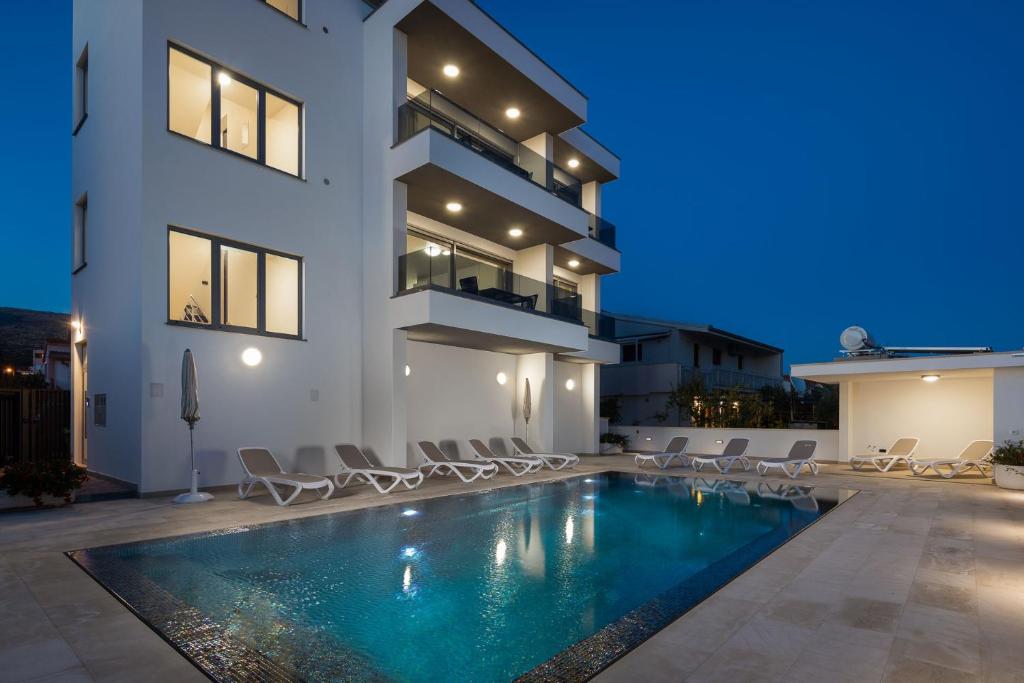 une villa avec une piscine la nuit dans l'établissement Apartment Prestige 1, à Trogir