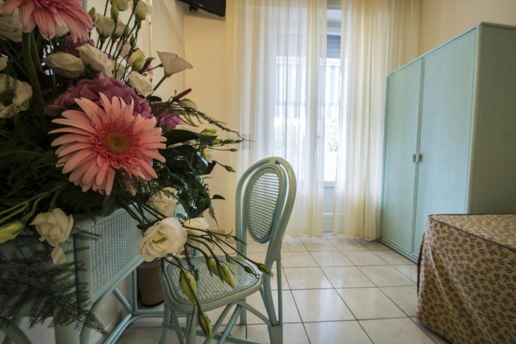 a room with two chairs and a vase of flowers at Hotel Riviera Blu in Tirrenia