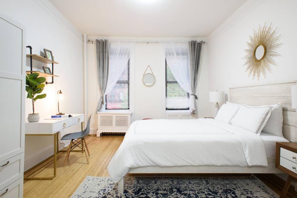 ein weißes Schlafzimmer mit einem großen Bett und einem Schreibtisch in der Unterkunft 1567-1A New 2br PRIME upper East APT W&D in New York