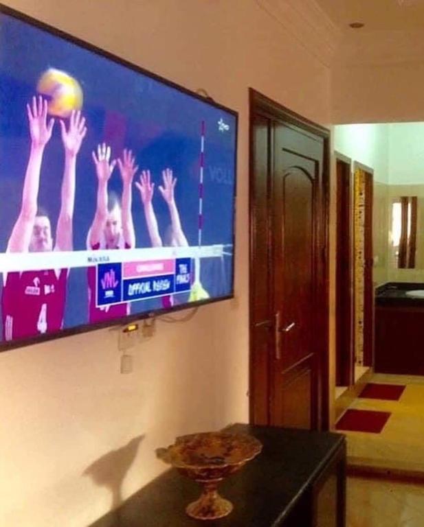 a tv on a wall with a volleyball game on it at Vacances à petit prix Lot Shems in Safi