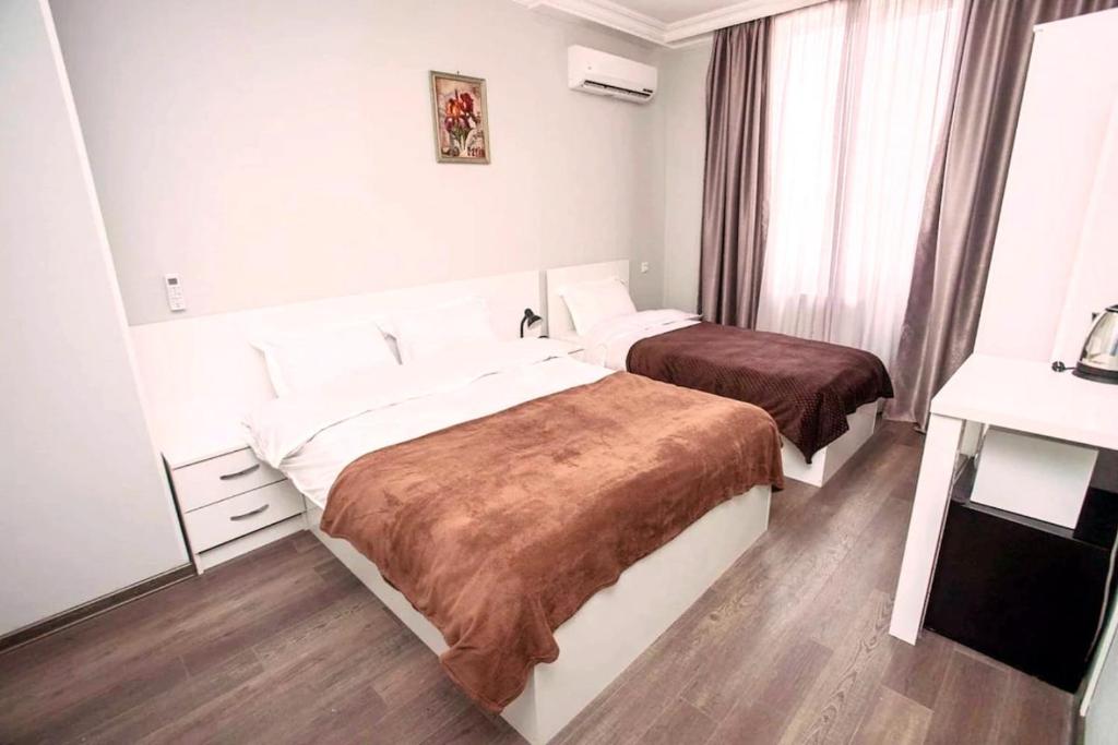 a hotel room with two beds and a desk at Astoria Sky in Tbilisi City