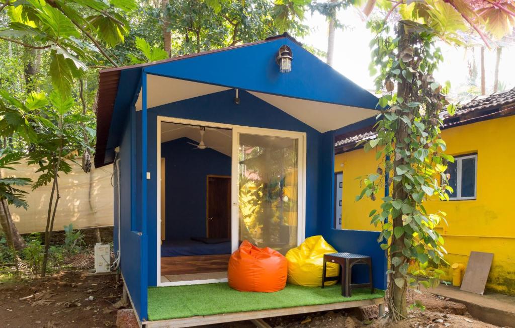 a blue and yellow house with orange bags in it at BunkNBrew in Palolem