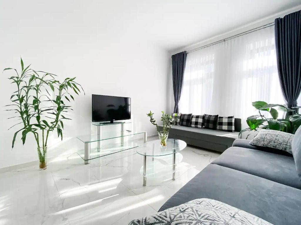 a living room with a couch and a glass table at 268 Leipzig Plagwitz Apartment Kulturviertel in Leipzig