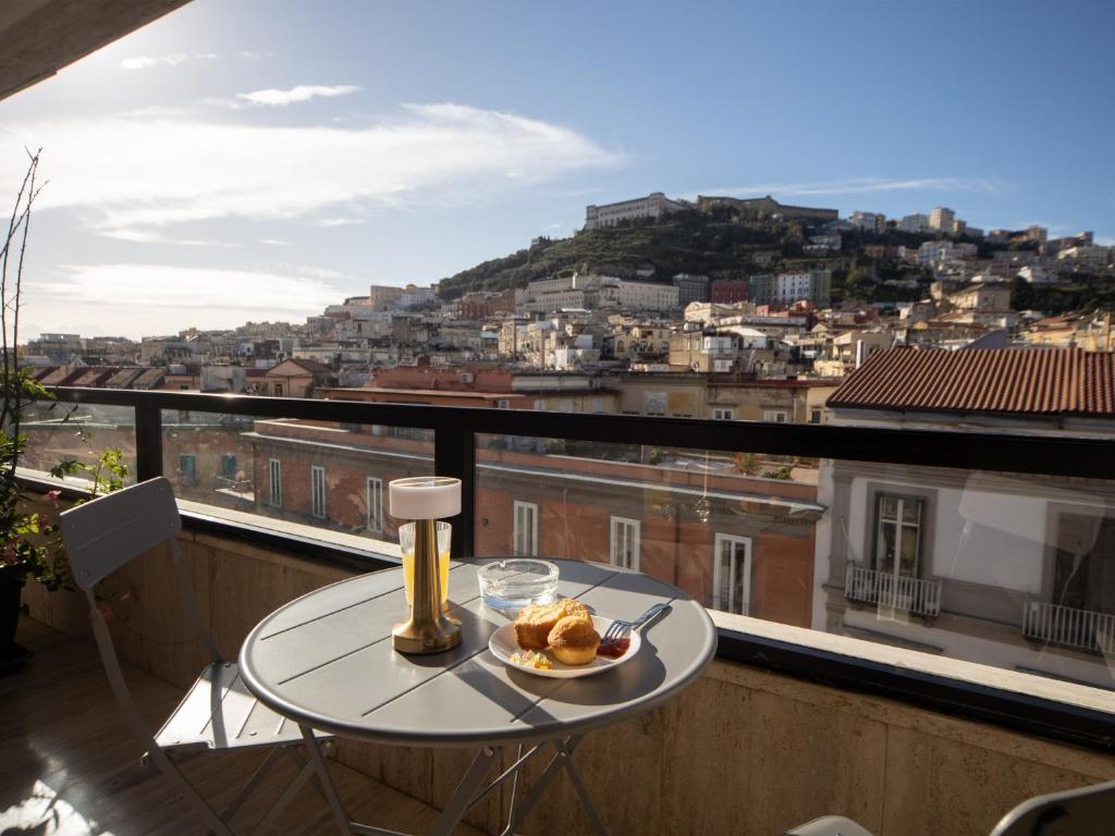 una mesa en un balcón con vistas a la ciudad en Salotto Borbonico, en Nápoles