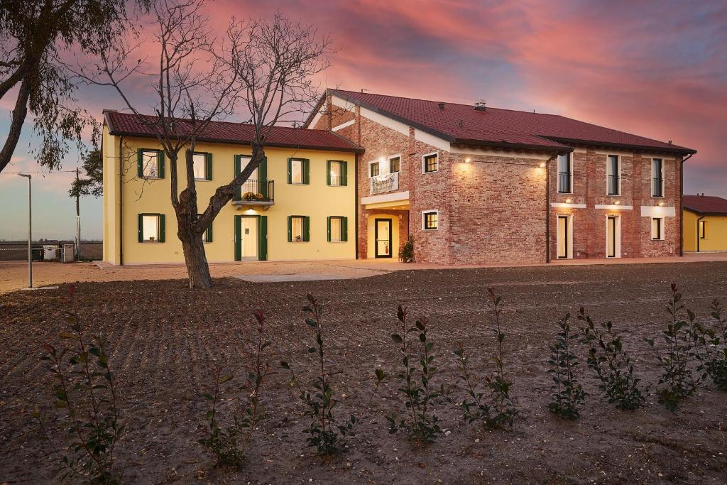 a house with a tree in front of it at Brussa Horse Oasi in Caorle