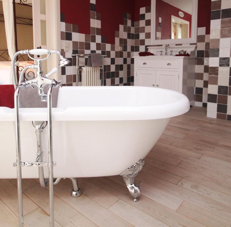 a white bath tub sitting in a bathroom at Comme à la Ferme in Durbuy