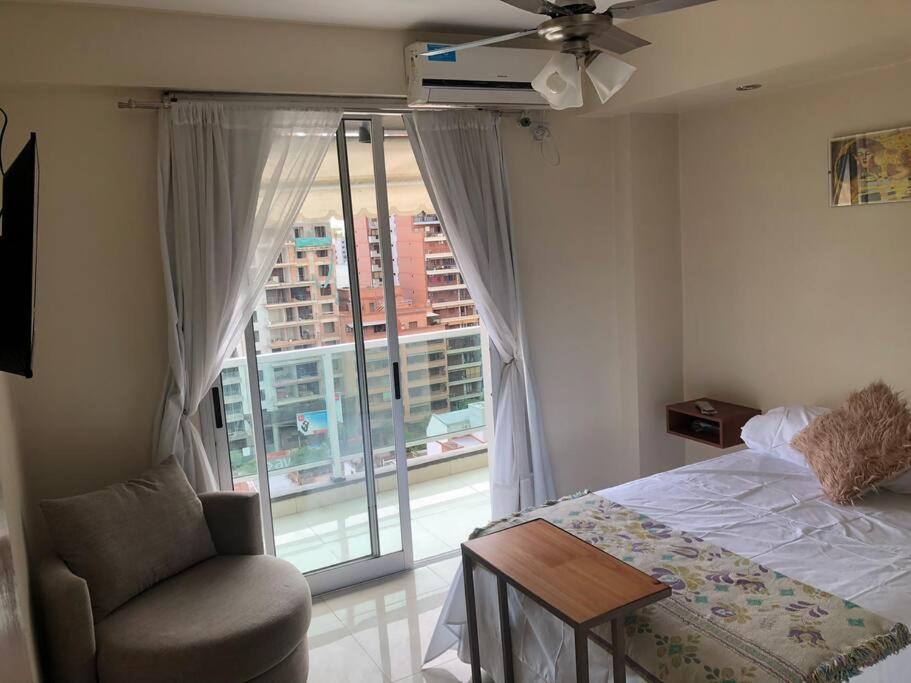 1 dormitorio con 1 cama, 1 silla y 1 ventana en Ultra comfy en Barrio Norte- un dormi con lavarrop en San Miguel de Tucumán