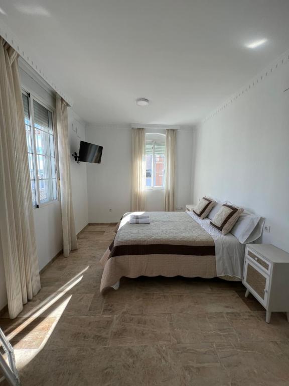 una camera da letto bianca con un letto grande e finestre di ATICO SUITE CLAUDIO MARCELO a Cordoba