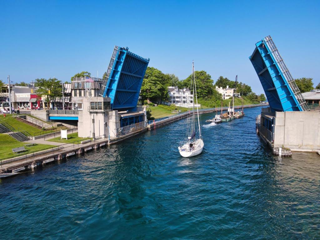 a sail boat in the water under a bridge at 117A Edgewater Inn Condo in Charlevoix