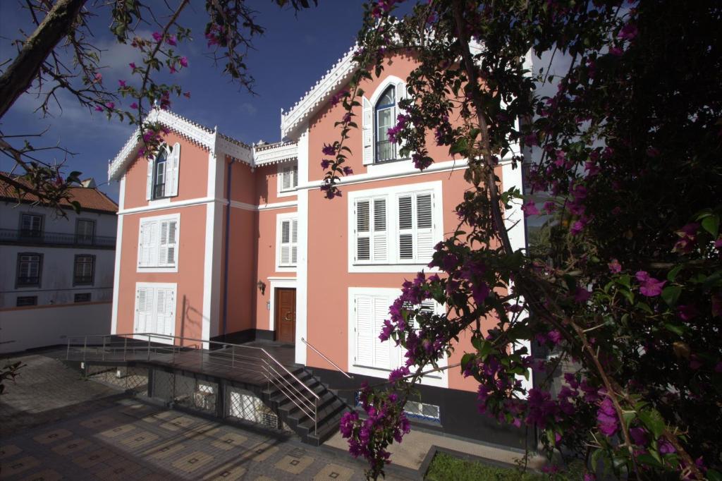 un edificio rosa con una scala di fronte di Rose Velvet ad Angra do Heroísmo