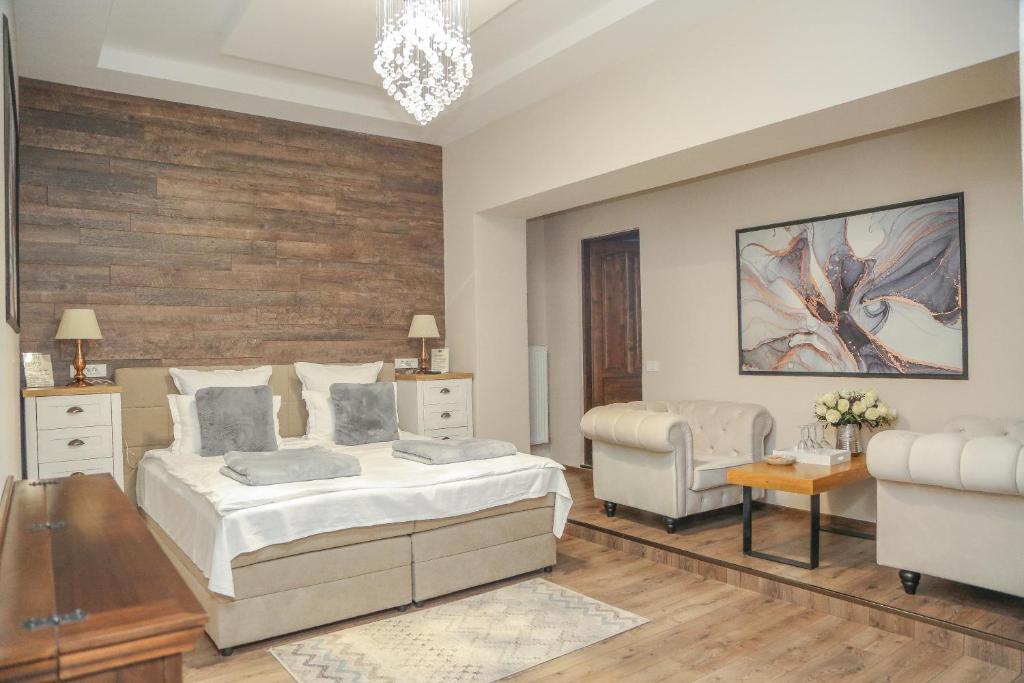 a bedroom with a bed and a chair and a table at ELEGANT ROOMS - ULTRACENTRAL - jacuzzi cu hidromasaj in Oradea