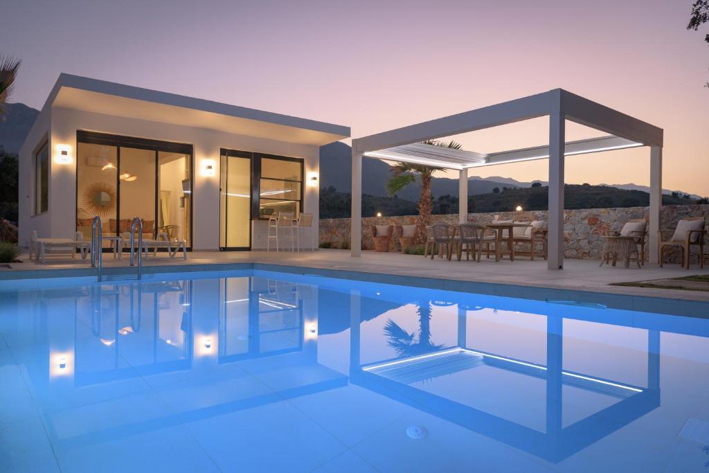 a villa with a swimming pool at dusk at pelagias villa lefka with heated pool in Mathés