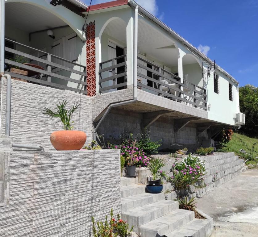 ein Haus mit einer Treppe, die auf einen Balkon führt in der Unterkunft Chez Axel in Le Marin