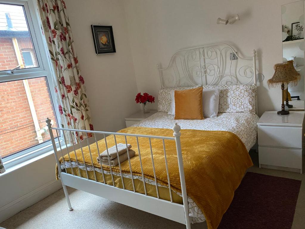 Charminster Homestay في بورنموث: غرفة نوم بسرير ونافذة