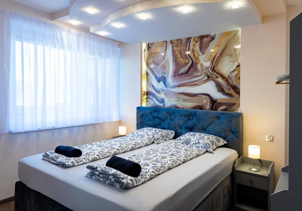 Dream Apartman 1 with Free Parking في جيور: سريرين في غرفة مع لوحة على الحائط