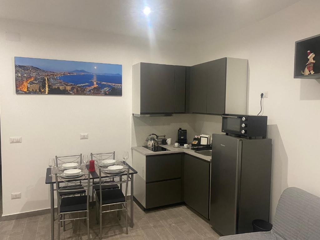 una piccola cucina con tavolo e frigorifero di The Nest Of Via Toledo a Napoli