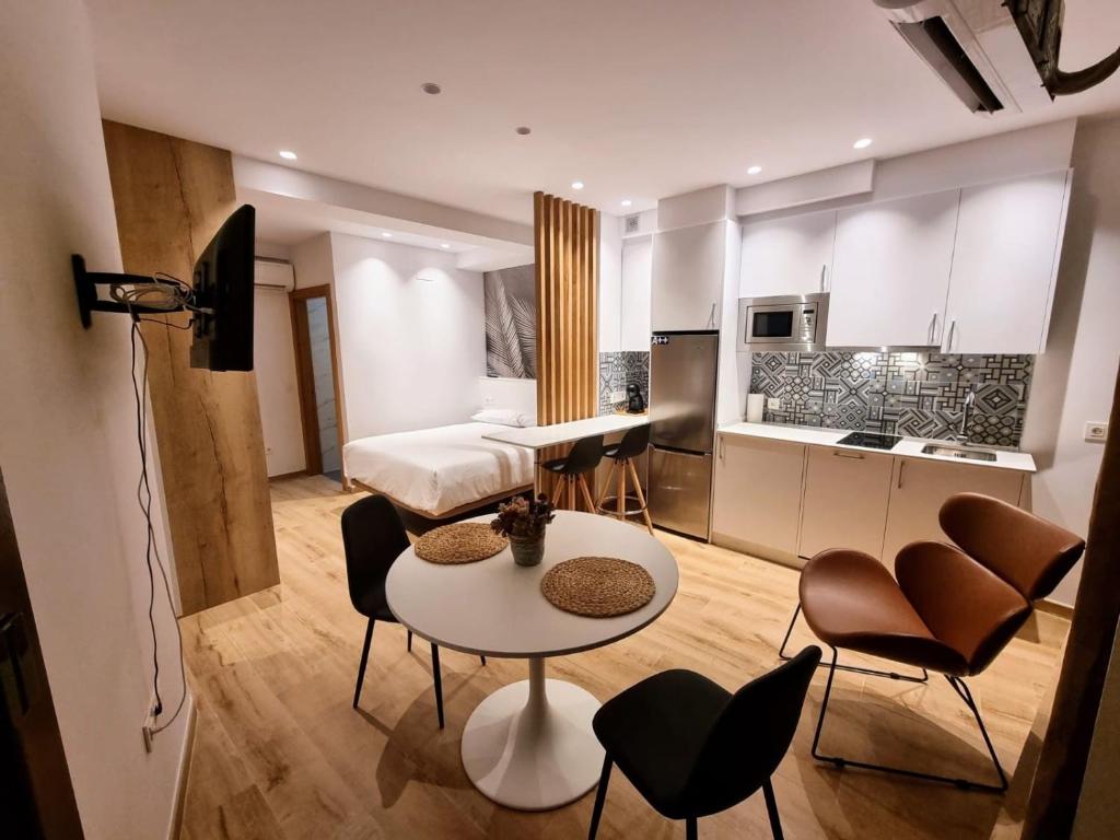 a living room with a table and chairs and a kitchen at Suites BERRUETA (Plaza Mayor) in León