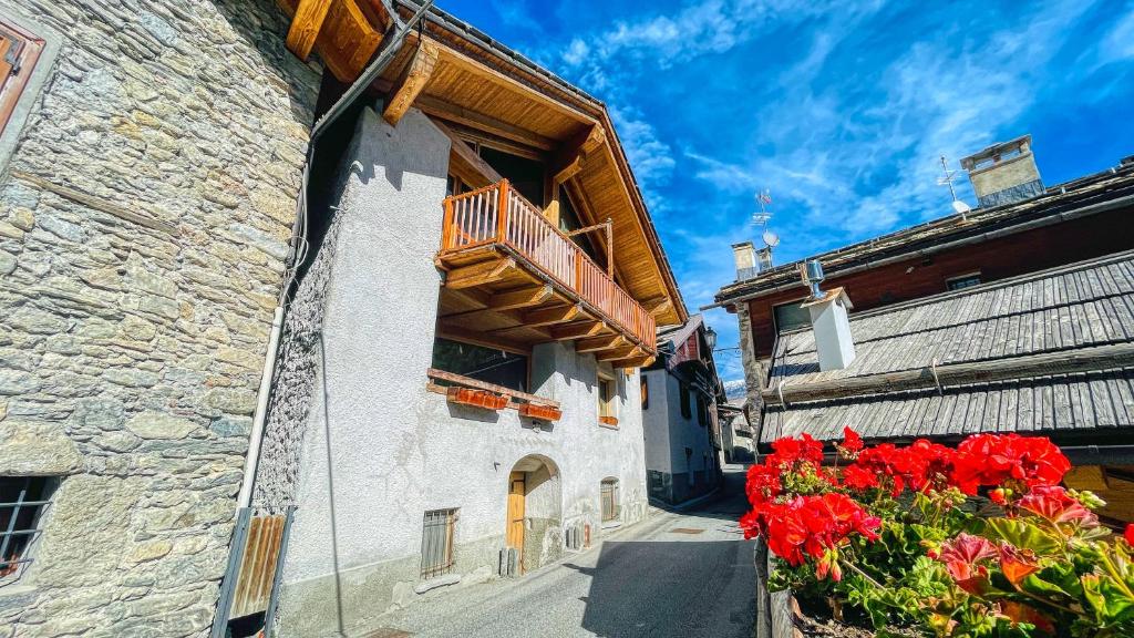 ein Gebäude mit einem Balkon und roten Blumen darauf in der Unterkunft Appartamento Melezet 80 - Affitti Brevi Italia in Bardonecchia