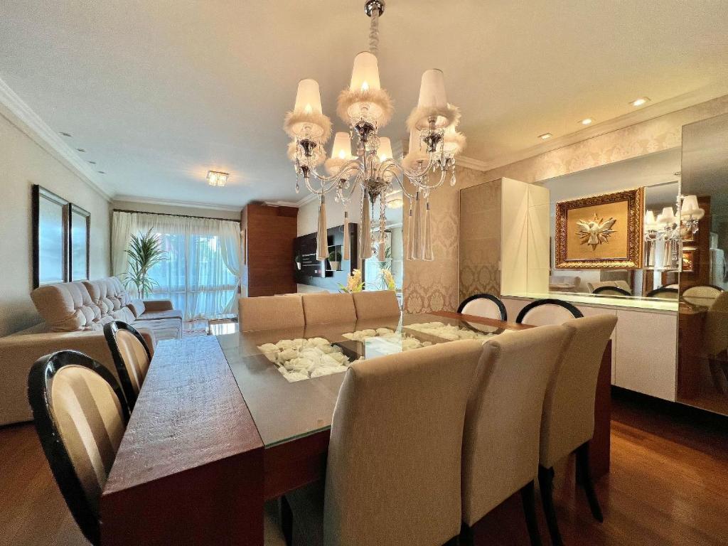 a dining room and living room with a table and chairs at Gramado Boulevard 404 - Apto no coração de Gramado, 300 metros Rua Coberta in Gramado