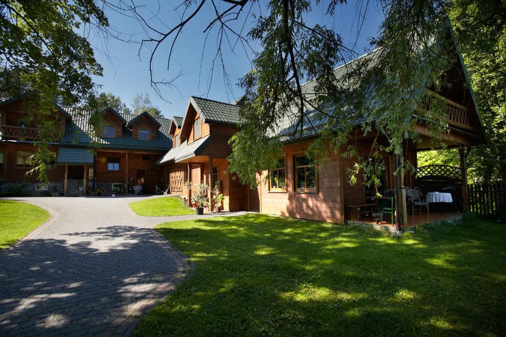 una casa con un patio de césped al lado de un edificio en Siedlisko Zatoka, en Augustów