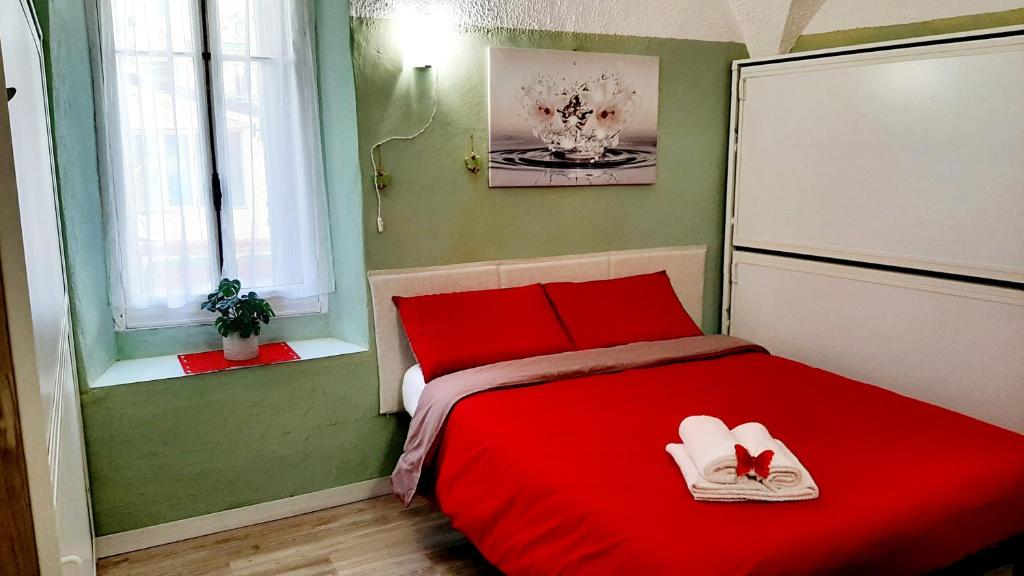 ein Schlafzimmer mit einem roten Bett mit zwei Schuhen drauf in der Unterkunft Casa Ninnì Sanremo in Sanremo