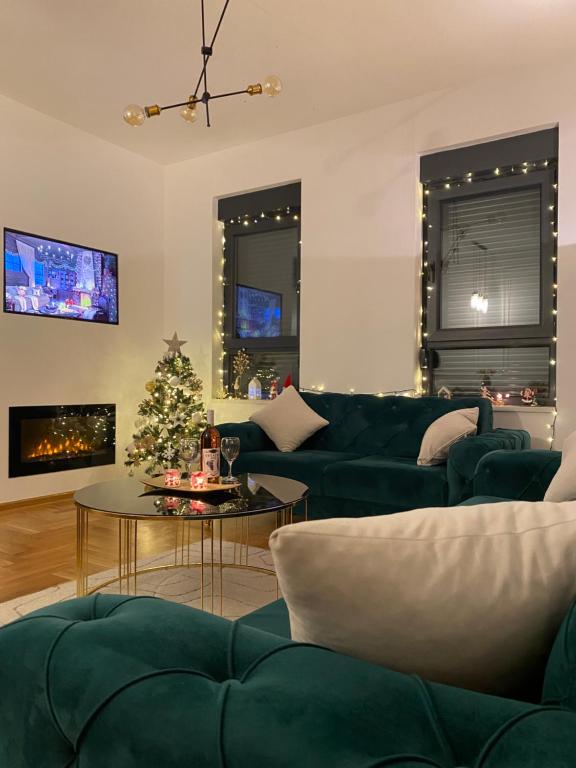 een woonkamer met een groene bank en een kerstboom bij Apartman Barocco in Trebinje