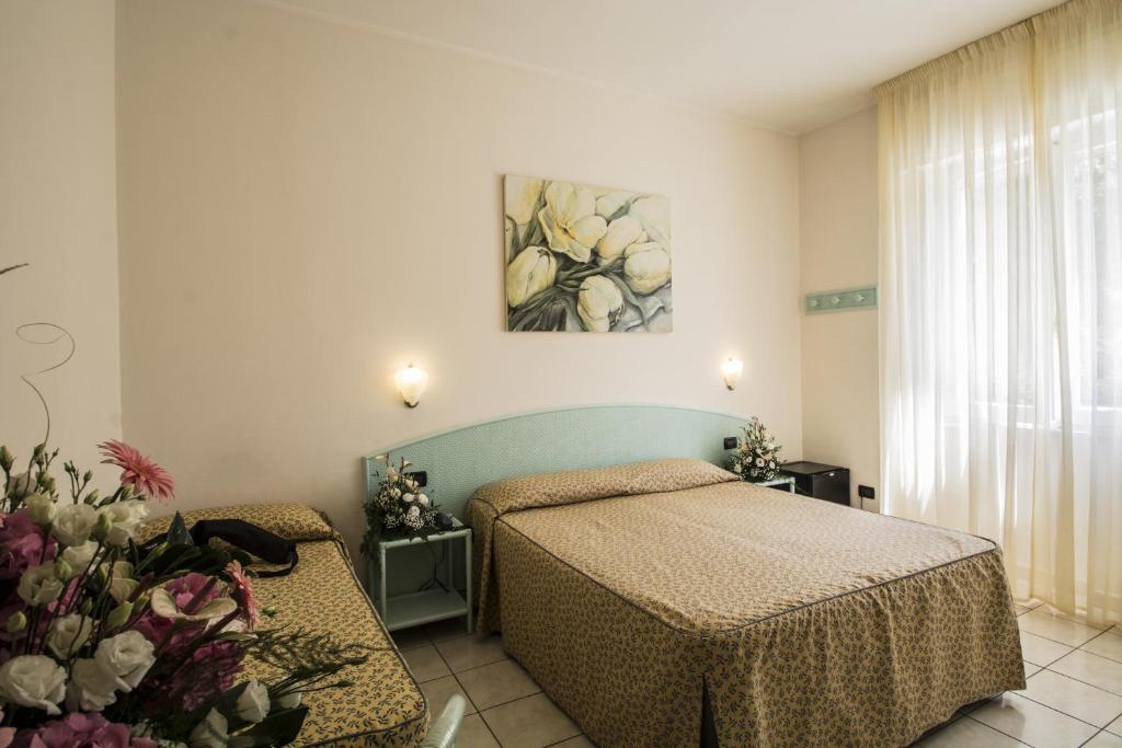 a bedroom with two beds and a painting on the wall at Hotel Riviera Blu in Tirrenia