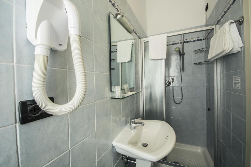 a bathroom with a sink and a shower and a mirror at Hotel Riviera Blu in Tirrenia