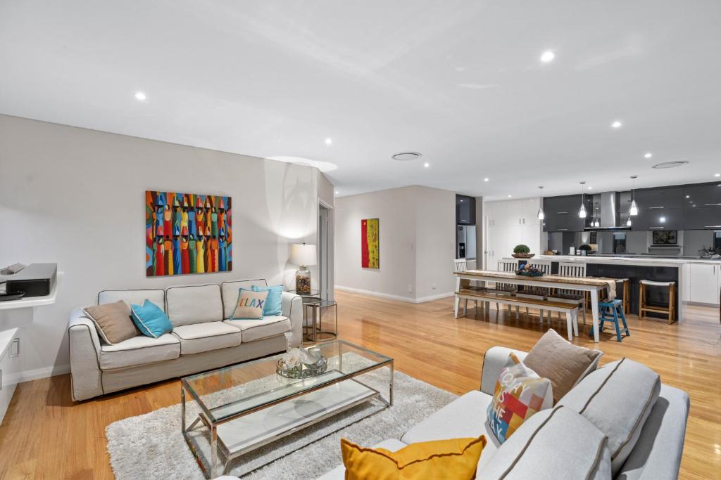 ein Wohnzimmer mit 2 Sofas und einer Küche in der Unterkunft Family Vacation Escapade Shops Beach and Sun Await in Perth