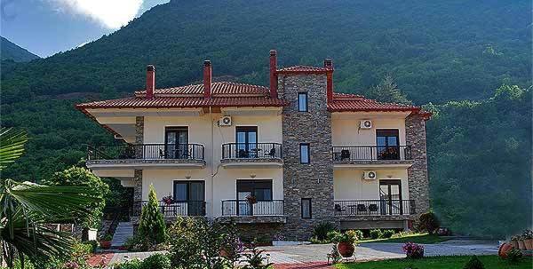 a large house with a mountain in the background at Ydraktis in Orma