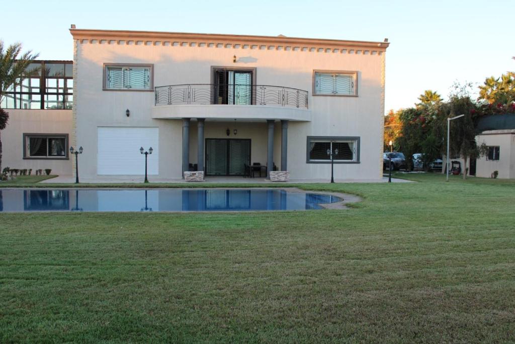 une maison avec une piscine en face de celle-ci dans l'établissement Jnane Ville Verte, à Casablanca