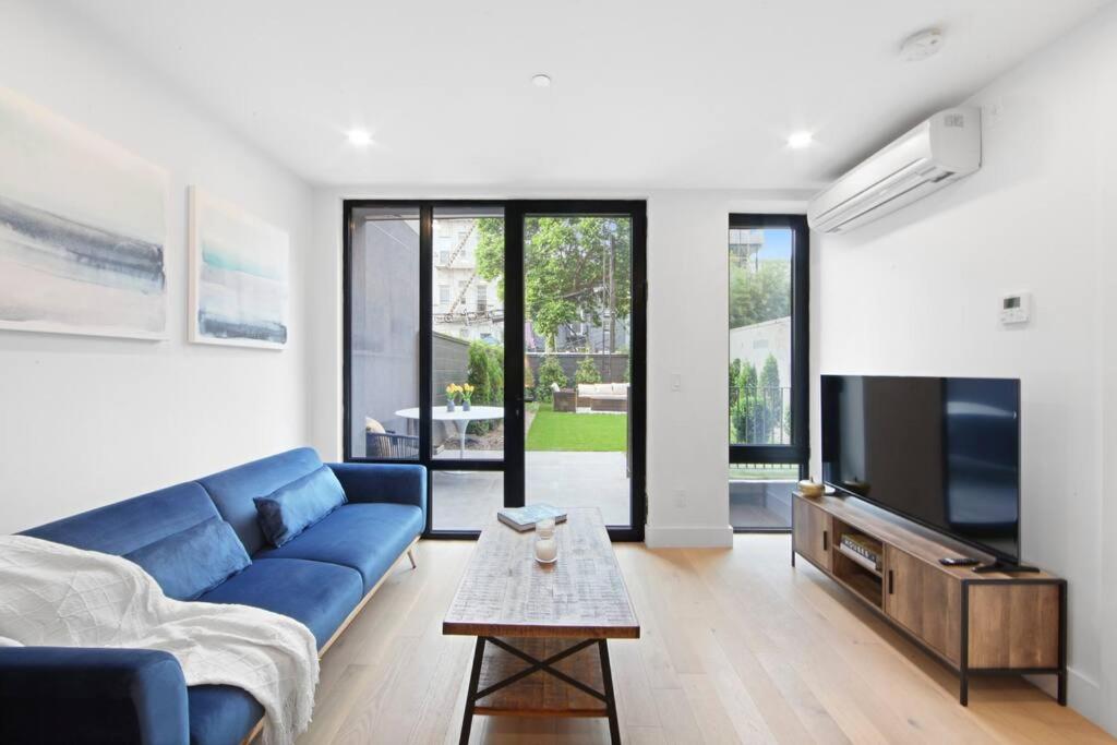 a living room with a blue couch and a tv at 149BK-101 New construction 2BR Private garden W-D in Brooklyn