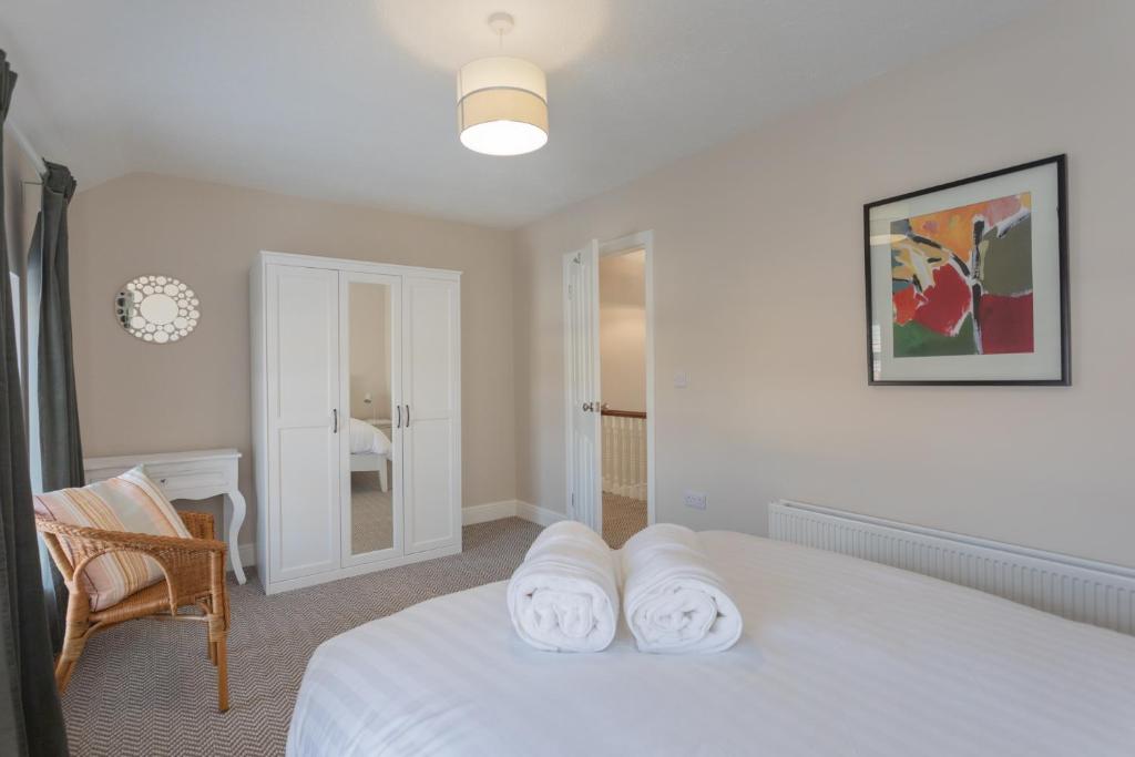 a bedroom with a bed with two towels on it at The Innkeeper’s Lodge Bushmills in Bushmills