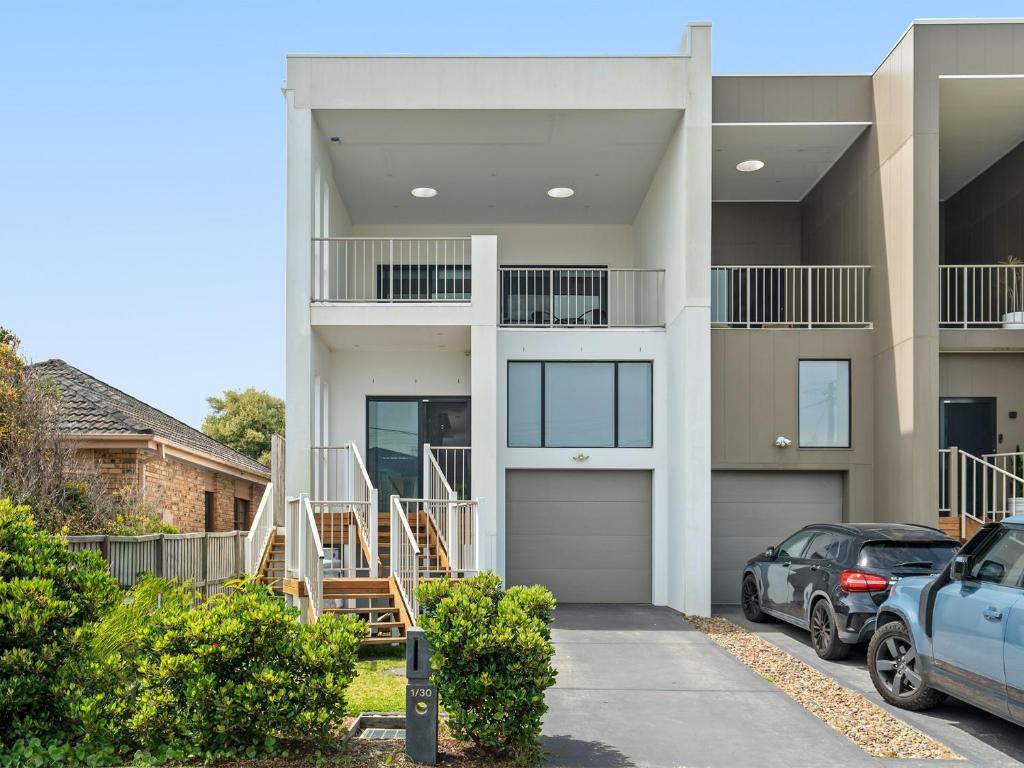 a house with a car parked in front of it at North Entrance Holiday Home in The Entrance