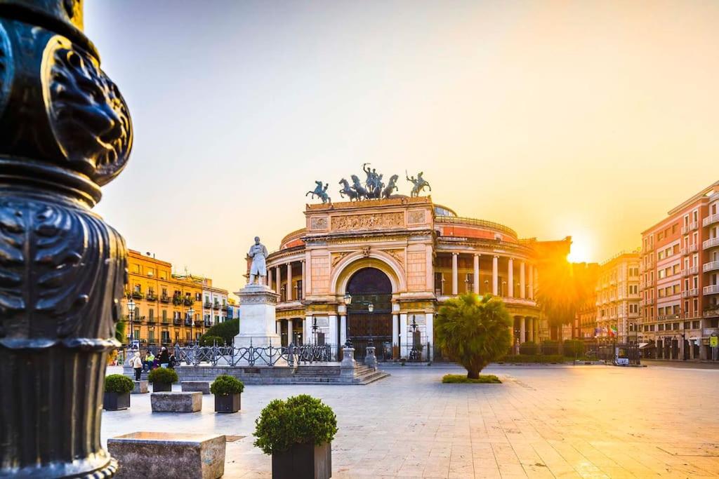 a large building with a statue in front of it at Carducci apartment in Palermo