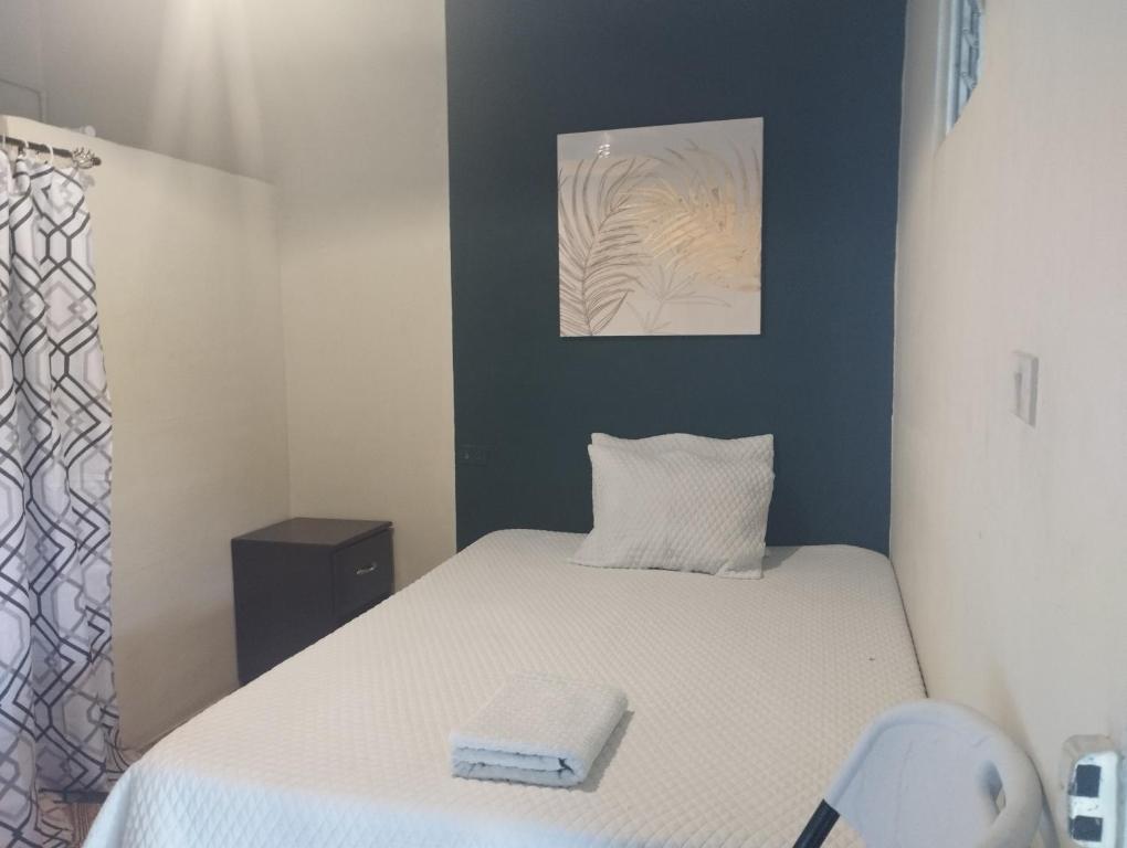 Metapán的住宿－Hostal Montecristo Metapan，一间小卧室,配有一张床和墙上的照片