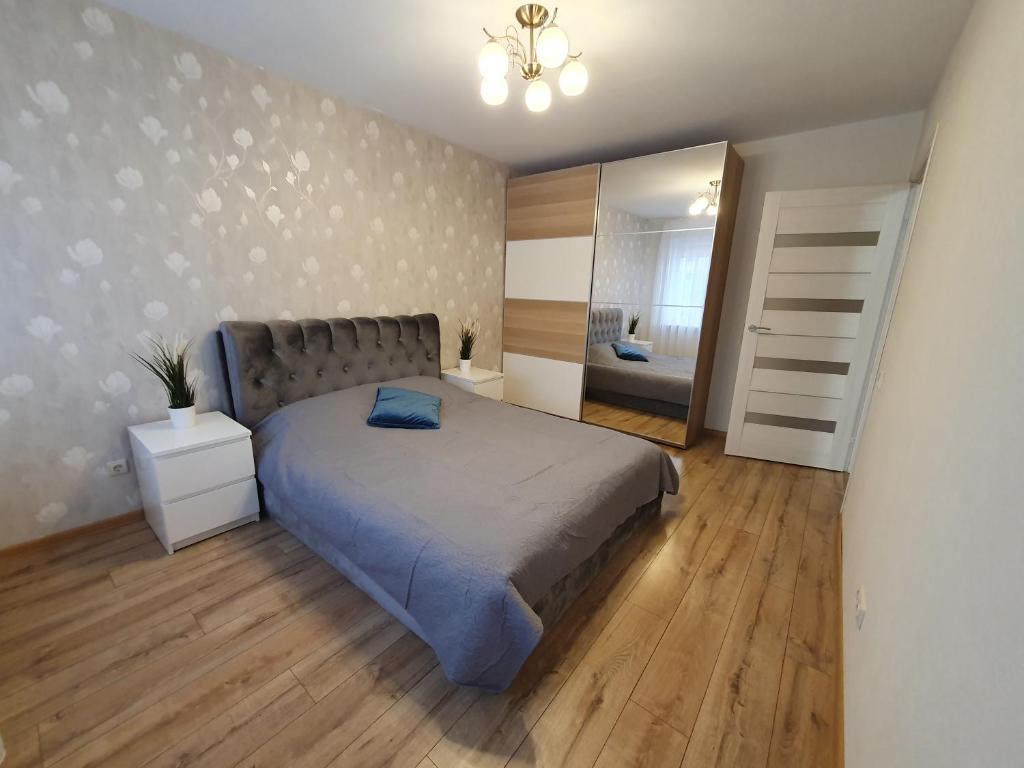 a bedroom with a large bed and a mirror at Dainai 1-Bedroom apartament. in Šiauliai