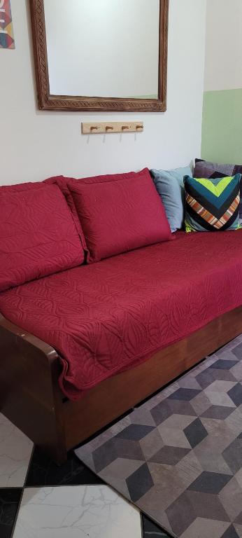 uma cama vermelha com um espelho na parede em Hostel Beto Carrero em Itajaí